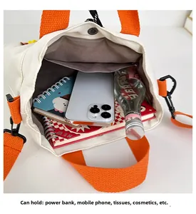 Detail view of nylon tote interior capacity with orange handles and metal snap closure