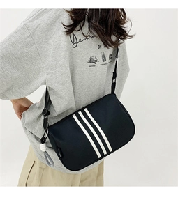 Detail der schwarzen Segeltuchtasche mit weißen Streifen und grauem Seilanhänger