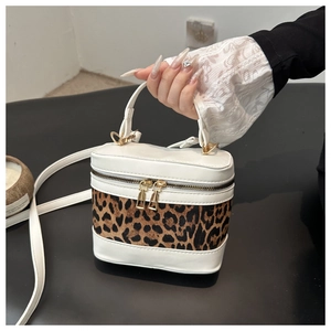 Detail of leopard print box bag with white faux leather and gold double zippers