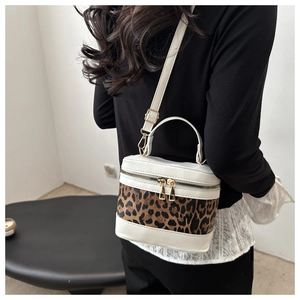 Detailed view of white crossbody box bag with leopard print panel and gold hardware
