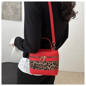Detailed back view of a red leopard print cylinder bucket bag with gold zippers