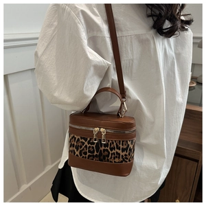 Detail of leopard print crossbody box bag featuring dual zippers and top handle