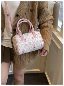 Close-up of pink leather handle and floral bear pattern on a cylindrical bucket bag