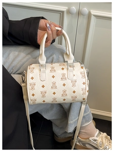 Detailoverzicht van de crème Boston-tas met berenprint en lychee-korrel lederen textuur