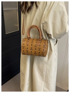 Bruine mini cilindertas met berenprint gedragen door een model in een trenchcoat