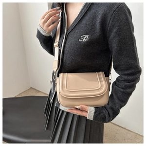 Detail of beige PU saddle bag with decorative stitching and wide adjustable strap