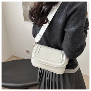 Detail of white rectangle crossbody bag with triple-layered stitching and nylon strap