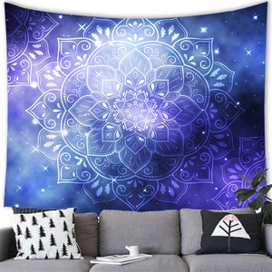Tapisserie mandala galaxie bleu et violette suspendue au-dessus d'un canapé gris