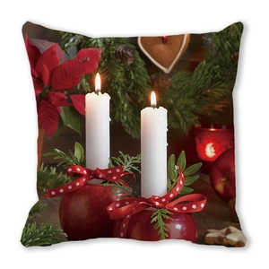 Close-up of peach skin fabric pillow featuring burning candles and festive pine branches