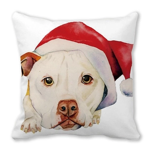 Detail eines weißen Hundes mit Weihnachtsmütze auf einem weichen quadratischen Dekokissen