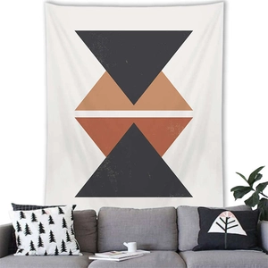 Minimalist Nordic geometric tapestry with orange and black triangular patterns over a sofa