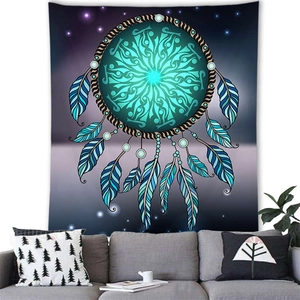 Detail of dreamcatcher tapestry with blue feathers hanging over a gray sofa