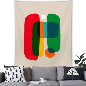 Detail of geometric abstract wall tapestry hanging above a modern sofa in a living room