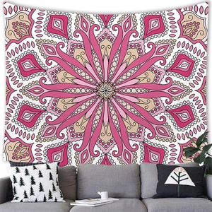Detailed texture of pink mandala tapestry hanging on a wall above a grey sofa with pillows
