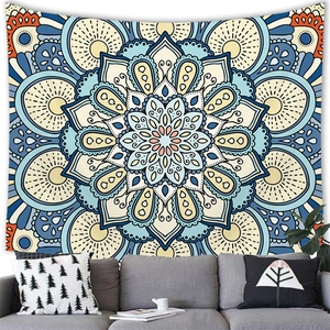 Detail view of a bohemian blue mandala tapestry on a white wall above a grey sofa