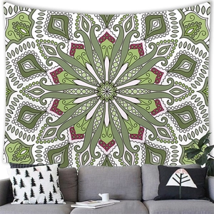 Bohemian mandala tapestry with geometric green and pink patterns on a white wall