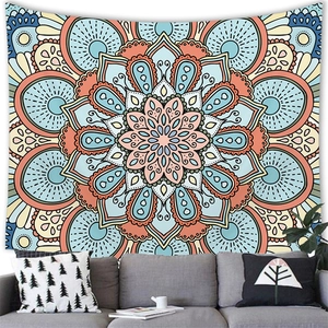 Detail of bohemian mandala tapestry featuring blue and orange lotus patterns on wall