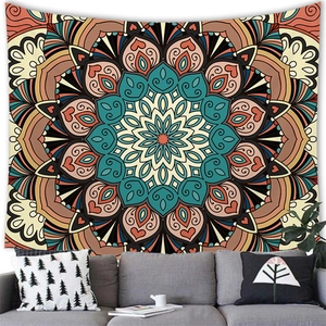 Detail of bohemian mandala tapestry hanging on a wall behind a modern grey sofa