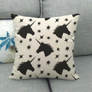 Detail of linen cushion cover showing black unicorn pattern and star texture on sofa