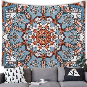Close-up of bohemian mandala tapestry with orange and blue geometric patterns in a cozy room