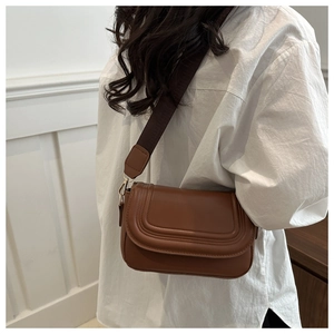 Detailed view of brown PU leather shoulder bag featuring U-shaped stitching and wide strap