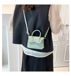 Chic mint green mini PU leather bag with lychee texture shown on an outfit