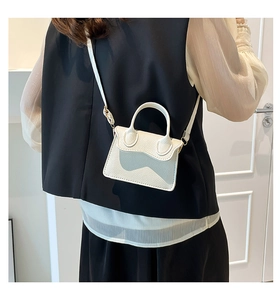 Détail du mini sac blanc en cuir grainé avec rabat au design ondulé élégant et chic