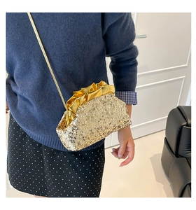 Dettaglio della chiusura dorata a onde e della trama fitta di paillettes della borsa