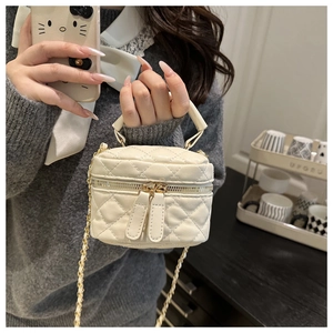 Detail of a beige quilted leather mini bag with gold chain strap and dual zipper closure