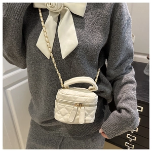 Detail of off-white quilted chain bag with double zippers and golden hardware accents