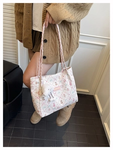 Detailed shot of white quilted tote bag with pink bear prints and plush charm