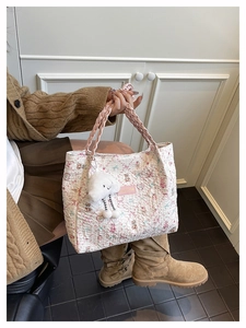 Close-up of quilted tote bag with floral bear prints and pink woven rope handle