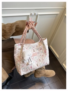 Close-up of floral quilted tote bag featuring bear patterns and woven pink handles