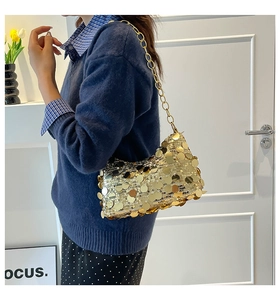 Detail of shimmering gold oversized sequins on a metallic chain shoulder hobo bag