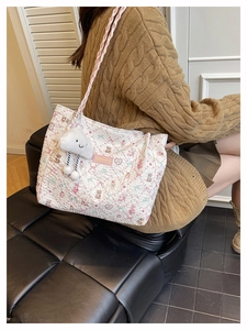Quilted tote bag detail featuring floral bear pattern and soft plush cloud charm