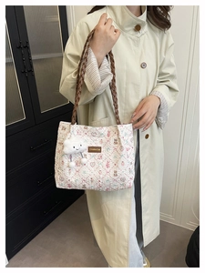 Dettaglio della borsa tote trapuntata a fiori con tracolla intrecciata marrone