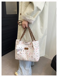 Detailed quilted texture of beige tote bag featuring cute cartoon bears and floral prints