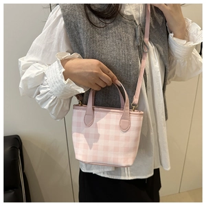 Detail showing the pink and white gingham canvas pattern and gold-tone hardware on the bag