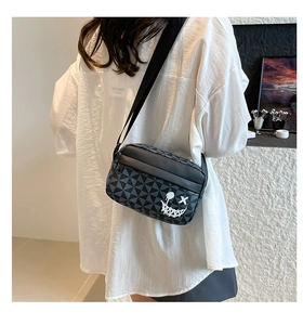 Detail of the cross-body bag featuring a geometric triangle pattern and graffiti smile logo