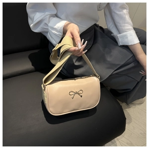 Détail de la boucle en métal sur le sac à bandoulière en cuir PU de couleur beige
