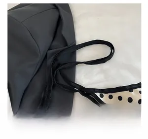 Detail shot of the comfortable shoulder strap and vintage polka dot print tote bag