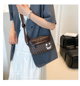 Chic brown geometric crossbody bag with graffiti smiley face worn by a model in a blazer