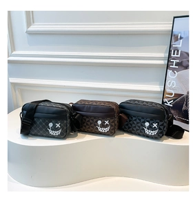 Three rectangular crossbody bags with geometric patterns and white smiley faces on display