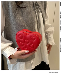 Close-up of a red heart-shaped mini handbag featuring 3D embossed heart patterns