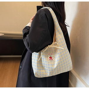Dettaglio della borsa tote in tela a quadretti con etichetta pomodoro e patch fatta a mano