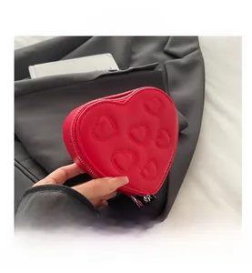 Close-up of red heart-shaped coin purse with embossed patterns and silver zipper