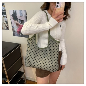 Polka dot green canvas tote bag shoulder view showing large capacity and soft texture