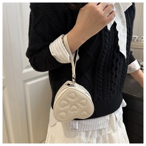 Close-up of a mini heart-shaped PU leather crossbody bag with embroidered heart patterns