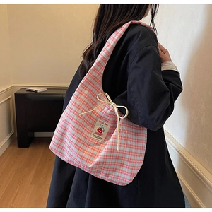 Dettaglio della borsa tote in tela a quadretti rosa e blu con etichetta fatta a mano e fiocco