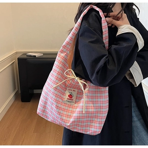Close-up of pink checkered canvas tote featuring a tomato patch and decorative bow